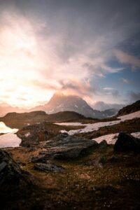 A breathtaking sunset over Pic du Midi d'Ossau in the Ossau Valley, showcasing rugged mountains and snow patches.